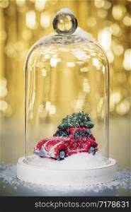 Christmas decoration on abstract gold background. Car with Christmas tree inside the Christmas snow globe.. Christmas decoration on abstract gold background, close up