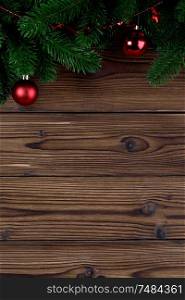 Christmas decoration on wooden background, fir tree branch, red baubles. Christmas decoration background