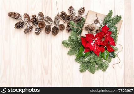 Christmas decoration. Pine branches with red flowers poinsettia on wooden background