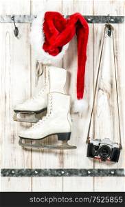 Christmas decoration. Red Santas hat, retro photo camera and white ice skates. Vintage style toned picture