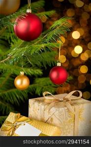 Christmas decoration tree, baubles and gifts on shining lights background