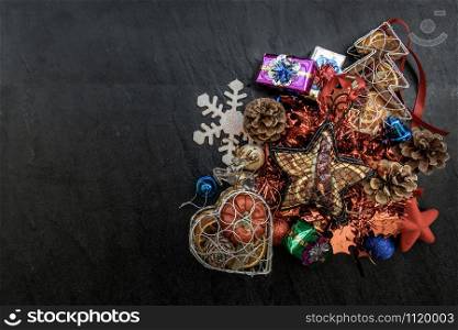 Christmas decoration. Twigs christmas tree, brown natural pine cones and and Xmas deer with variety of fruits on dark background. Top view, copy space.