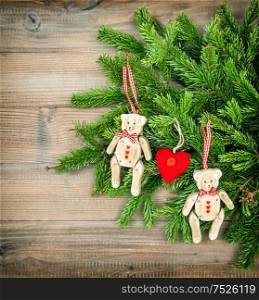 Christmas Decoration. Vintage style toys Teddy Bear with evegreen twigs on wooden background