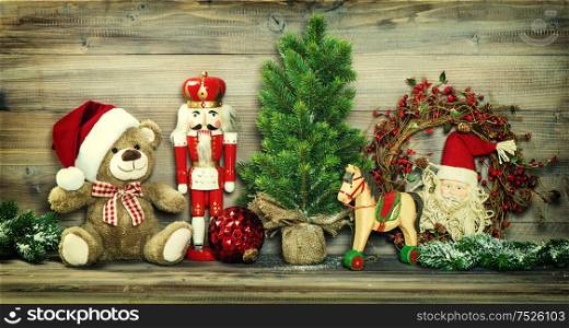 Christmas decoration. Vintage toys Teddy Bear, rocking horse and Nutcracker. No name mass production ware. Retro style toned photo with vignette