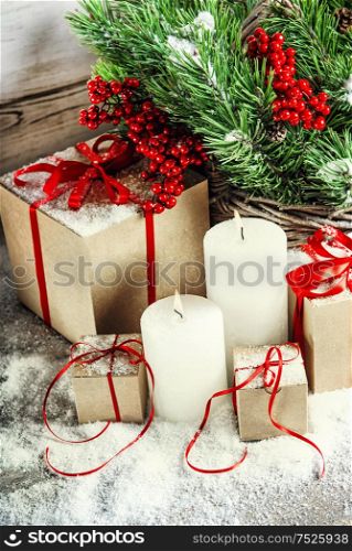 Christmas decoration with burning candles and gift box. Christmas tree branches