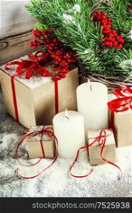Christmas decoration with burning candles and gift box. Christmas tree branches