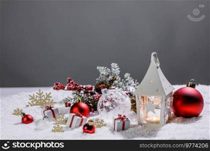 Christmas decoration with candle in lantern baubles and gifts on snow. Christmas decoration lantern