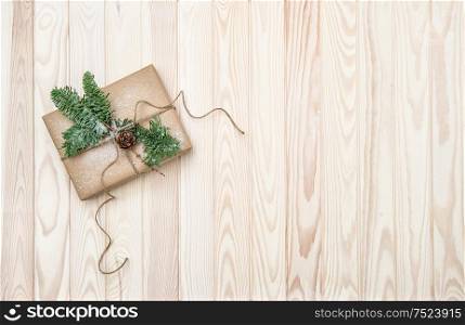 Christmas decoration with craft paper wrapped gift and pine tree branches