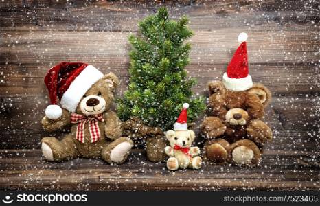 Christmas decoration with funny toys Teddy Bear family. Vintage style toned picture with falling snow effect