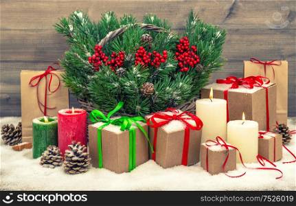 Christmas decoration with gift boxes and burning candles. Vintage style toned picture