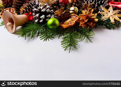 Christmas decoration with golden pine cones and handmade straw ornaments. Christmas greeting background with baubles and dried orange slices. Copy space.