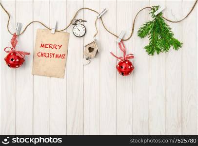 Christmas decoration with greeting card. Christmas tree branches on bright wooden background