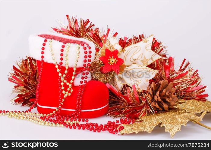 Christmas decoration with Santa&rsquo;s red boot, garland, beads isolated on gray background.