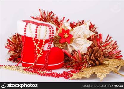 Christmas decoration with Santa&rsquo;s red boot, garland, beads isolated on gray background.