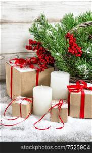 Christmas decoration with white candles and gift box. Christmas tree branches