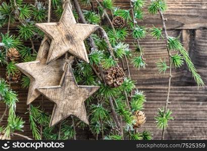 Christmas decoration wooden stars and pine tree branches. Holidays background. Vintage style toned