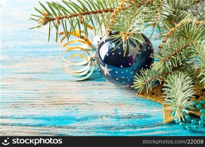 Christmas decorations and fir branch on a blue wooden background