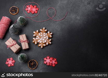 Christmas decorations and gingerbreads on a dark concrete table. Preparing and decorating the house for holiday. Delicious gingerbread cookies with honey, ginger and cinnamon. Winter composition