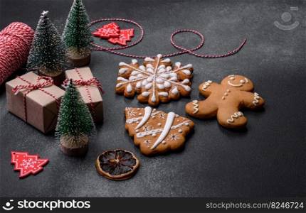 Christmas decorations and gingerbreads on a dark concrete table. Preparing and decorating the house for holiday. Delicious gingerbread cookies with honey, ginger and cinnamon. Winter composition