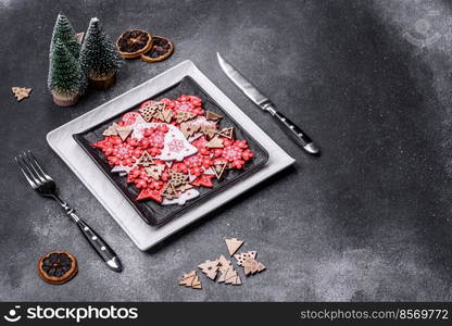 Christmas decorations and gingerbreads on a dark concrete table. Preparing and decorating the house for holiday. Christmas decorations and gingerbreads on a dark concrete table. Getting ready to celebration