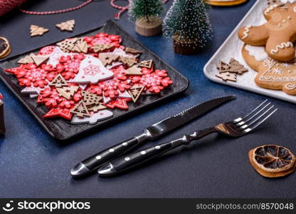 Christmas decorations and gingerbreads on a dark concrete table. Preparing and decorating the house for holiday. Christmas decorations and gingerbreads on a dark concrete table. Getting ready to celebration