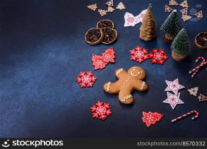 Christmas decorations and gingerbreads on a dark concrete table. Preparing and decorating the house for holiday. Christmas decorations and gingerbreads on a dark concrete table