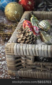Christmas decorations basket. Braided straw basket full of cones and Christmas ornaments.