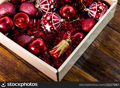 Christmas decorations in a box. Christmas concept. Box with red Christmas balls and garlands.