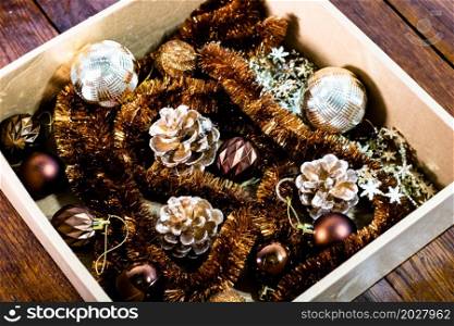 Christmas decorations in a box. Christmas concept. Christmas balls, pine cones, garlands.