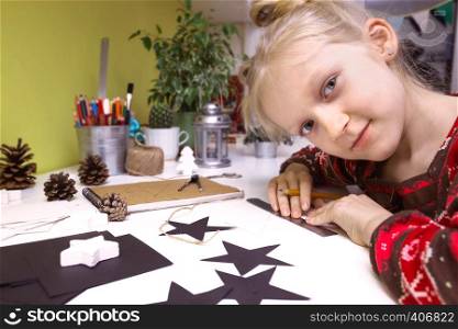 Christmas decorations. little girl made garlands stars