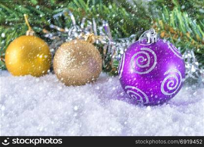 Christmas decorations on a background of blurred Christmas tree branches. Cold toning
