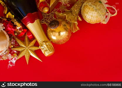 christmas decorations with bottle of champagne on red background