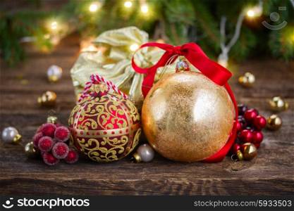 christmas decorations with gift box. golden christmas balls and gift box with defocused christmas lights in background