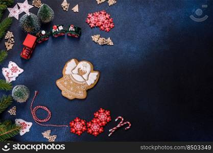 Christmas Decorations with Gingerbread man,fir tree branches and christmas background. Christmas homemade gingerbread cookies on a dark concrete table table