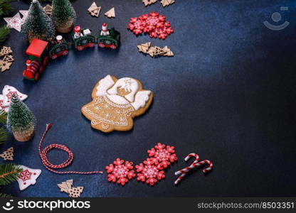 Christmas Decorations with Gingerbread man,fir tree branches and christmas background. Christmas homemade gingerbread cookies on a dark concrete table table