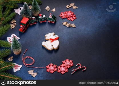 Christmas Decorations with Gingerbread man,fir tree branches and christmas background. Christmas homemade gingerbread cookies on a dark concrete table table