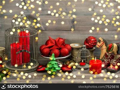 Christmas decorations with red candles, baubles, stars and rocking horse. retro style toned picture golden lights