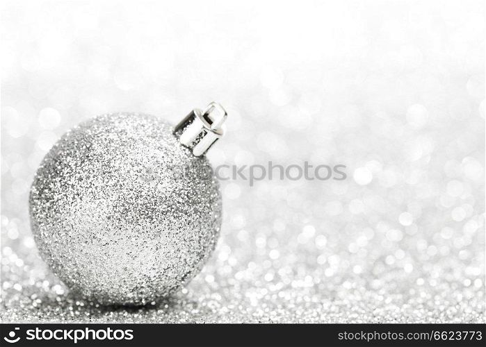 Christmas decorative ball on light silver bokeh background