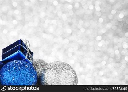 Christmas decorative balls and gifts on shiny silver background