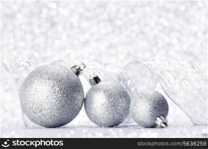 Christmas decorative balls and ribbon on silver glitter background