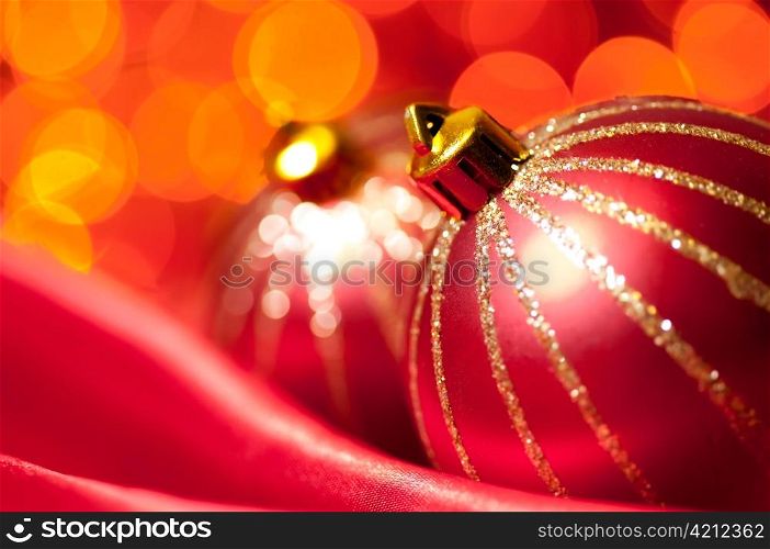 christmas decorative balls on red silk against blurred lights on background, shallow DoF