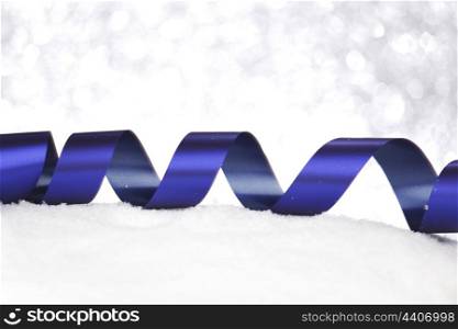 Christmas decorative blue ribbon on snow