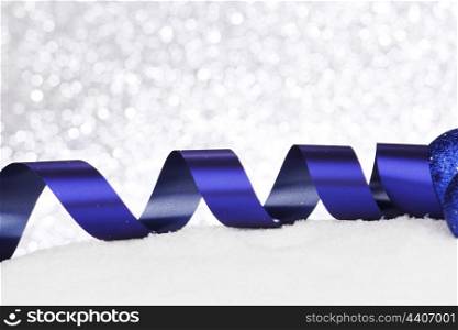Christmas decorative blue ribbon on snow