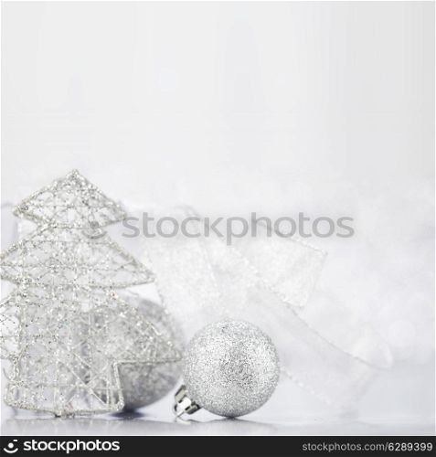 Christmas decorative fir and balls on light silver bokeh background