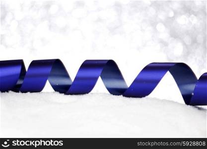 Christmas decorative ribbons on snow close-up