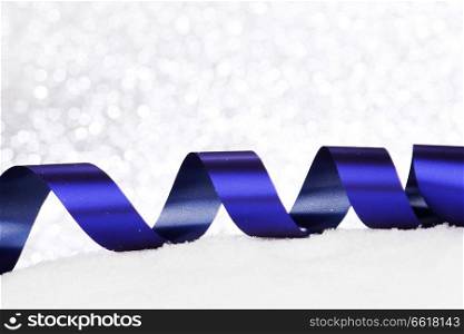 Christmas decorative ribbons on snow close-up