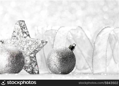 Christmas decorative silver star and balls on shiny glitters background