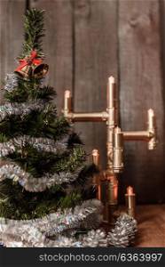Christmas decorative tree is adorned with rain stands on the table with a lit lamp lights