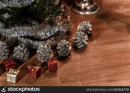 Christmas decorative tree is adorned with rain stands on the table with gifts and silver cones