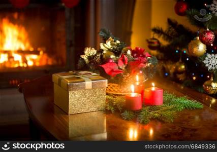 Christmas decorative wreath with burning red candles on table